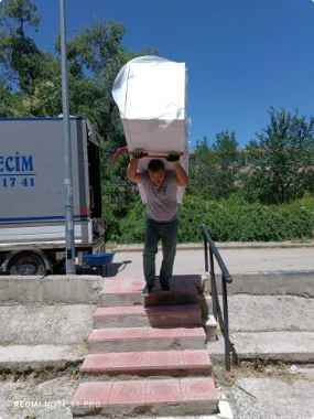 Paketlenmiş eşyayı taşıyan ekip üyesi